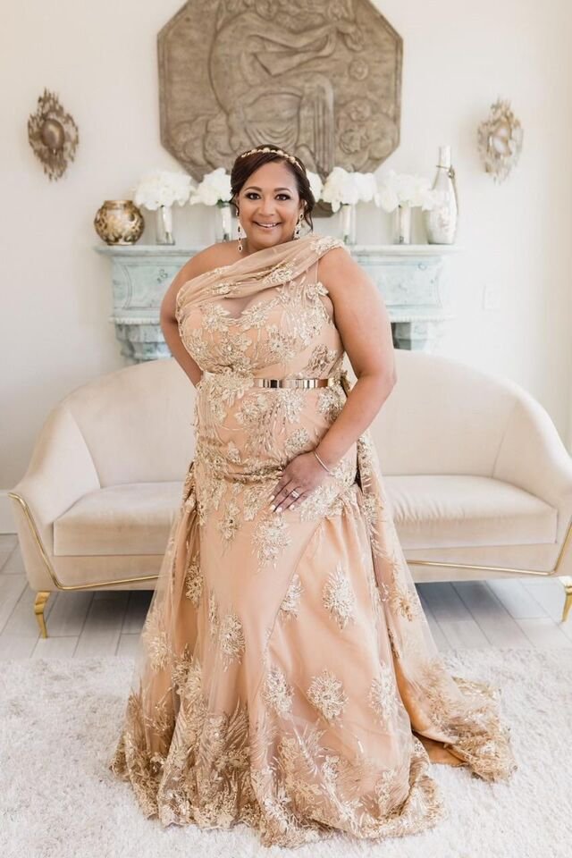 Client in a custom gold embroidered one-shoulder gown with metallic belt
